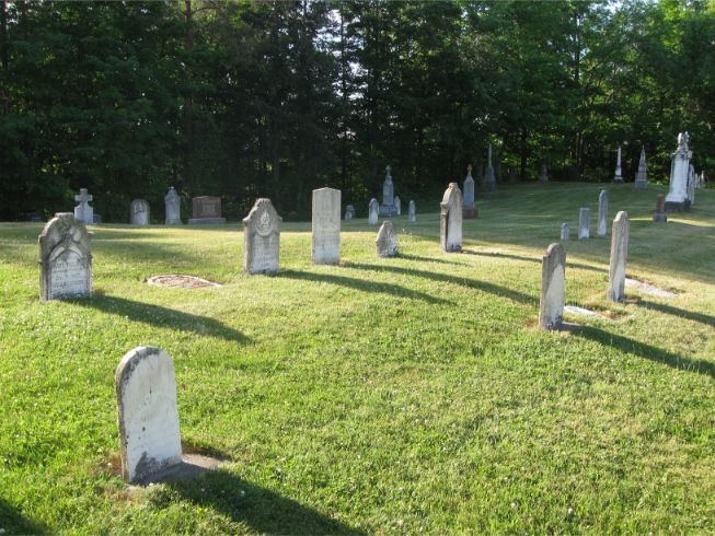 Old headstones on a green lawn